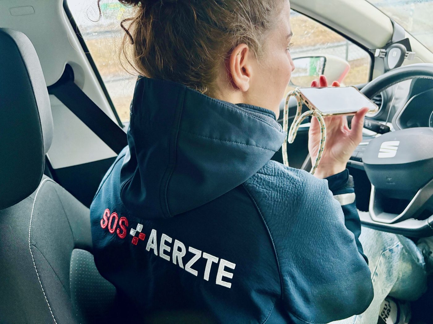 Mitarbeiterin von SOS Ärzte Turicum AG diktiert im Einsatzfahrzeug in ihr Smartphone